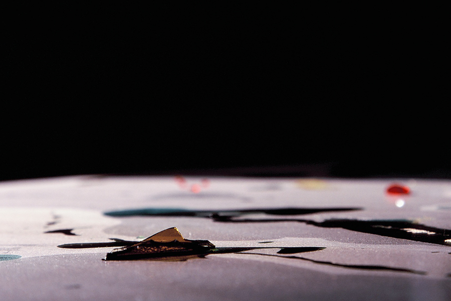 Low-angle close-up of glass fragments and liquid on the table