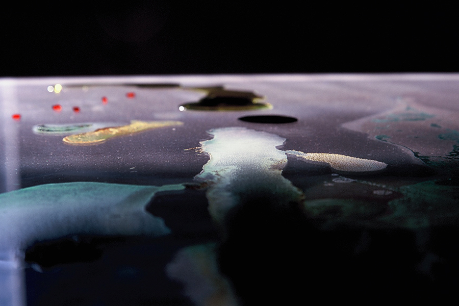 Low-angle close-up of liquid and solid materials on glass