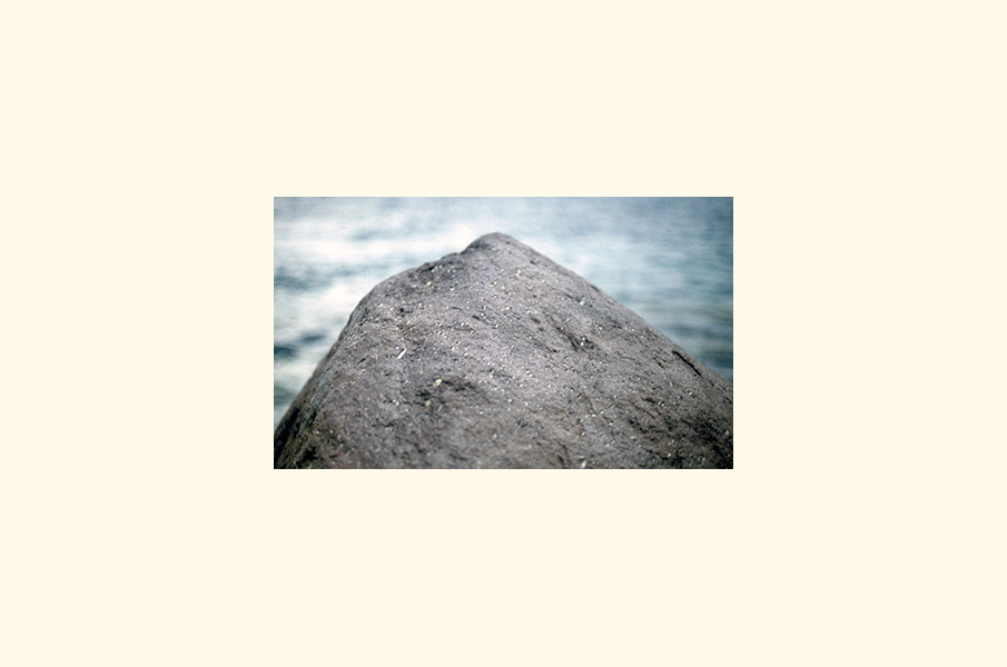 A dark rock against water
